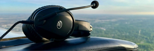 Aviation headset on an airplane dashboard with a scenic view outside